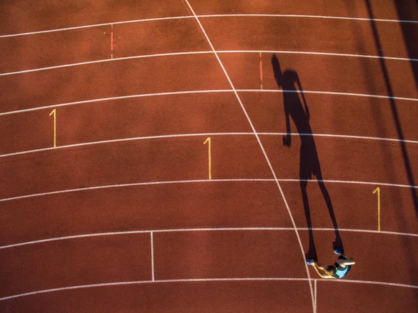 Tiro de un joven atleta entrenando en una pista de carreras — Foto de Stock