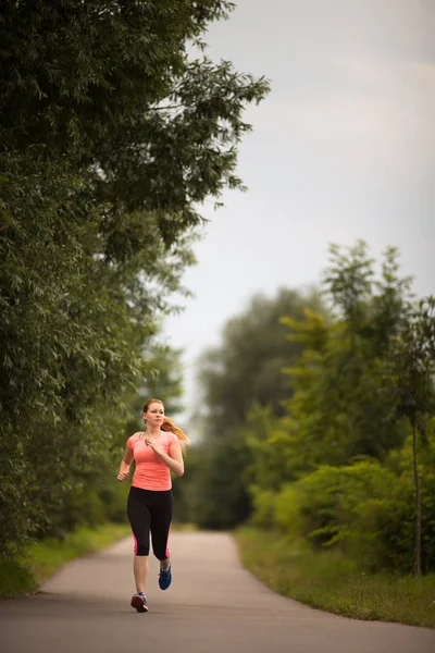 Mujer joven corriendo al aire libre en un hermoso día soleado de invierno / otoño —  Fotos de Stock