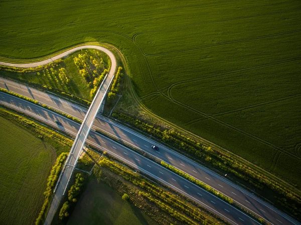 Vista aérea de uma estrada em meio a campos com carros nele — Fotografia de Stock