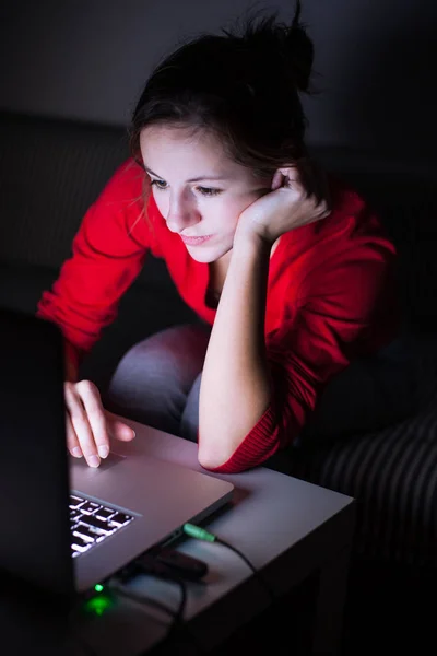 Ung kvinna som arbetar på hennes laptop sent på natten — Stockfoto