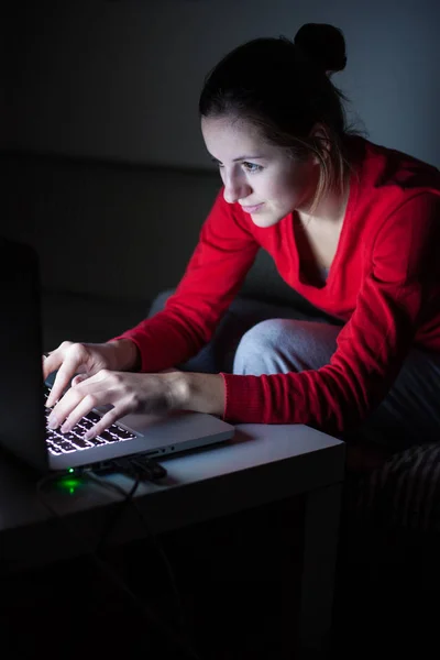 Mujer joven que trabaja en su computadora portátil tarde en la noche - quemando el mi —  Fotos de Stock