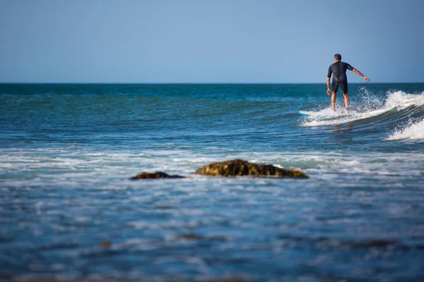 Giovane ragazzo che naviga sull'onda in una giornata di sole — Foto Stock
