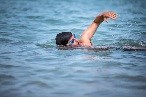 Триатлонист плавает вольным стилем в океане — стоковое фото