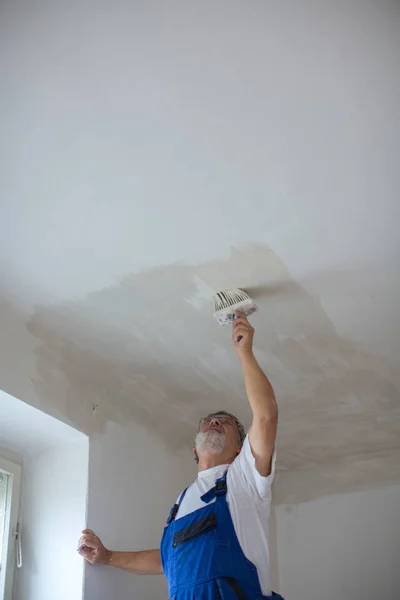 Senior Maler Mann bei der Arbeit mit einem Farbeimer, Wandmalerei — Stockfoto