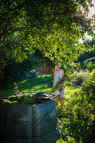 Pretty, young woman gardening in her garden, cutting branches — Stock Photo, Image