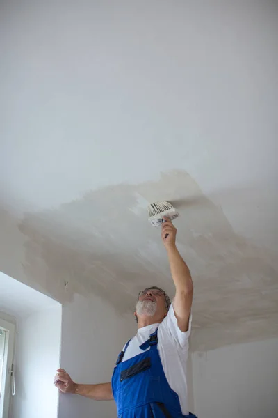 Senior painter man at work with a paint bucket, wall painting — Stock Image Senior painter man at work with a paint bucket, wall painting Stock Image