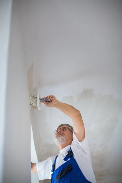 Senior painter man at work with a paint bucket, wall painting co — Stock Image Senior painter man at work with a paint bucket, wall painting co Stock Picture