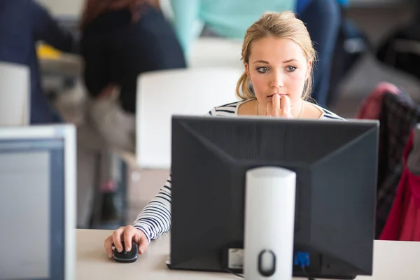 Estudante bonita, olhando para uma tela de computador desktop — Fotografia de Stock