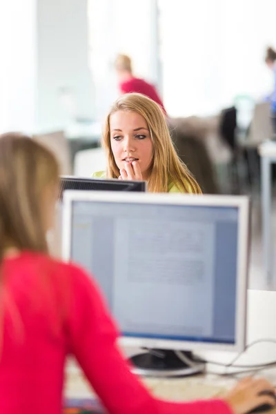 Estudiante guapa y femenina mirando una pantalla de computadora de escritorio —  Fotos de Stock