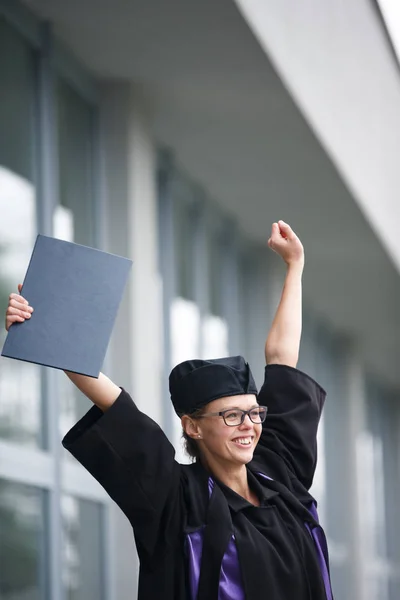 Mooie, jonge vrouw vreugdevol vieren haar afstuderen — Stockfoto