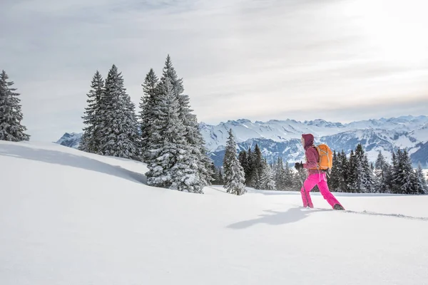Гарненька, молода жінка сніжить у високих горах — стокове фото