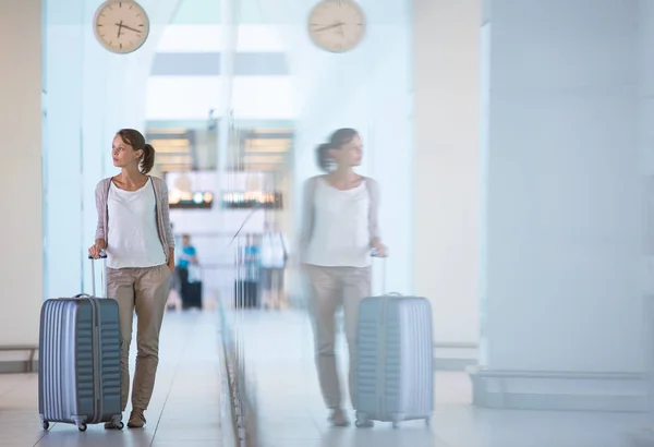 Jonge vrouwelijke passagier op de luchthaven, wachten op haar vertraagde f — Stockfoto