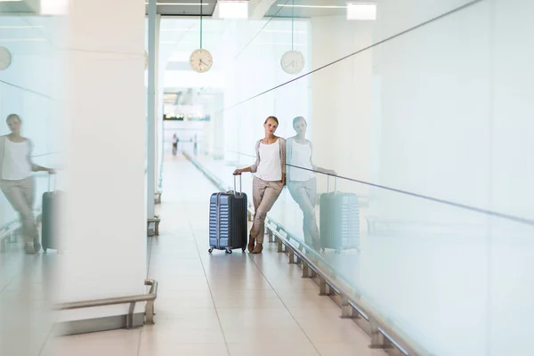 Jonge vrouwelijke passagier op de luchthaven, wachten op haar vertraagde f — Stockfoto