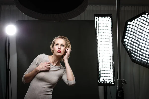 Beautiful female model posing in a photographic studio surrounde — Stock Photo, Image