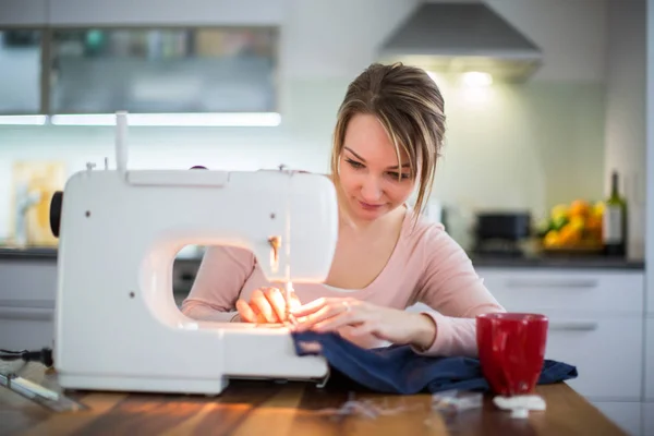Hermosa mujer joven cosiendo ropa con máquina de coser —  Fotos de Stock