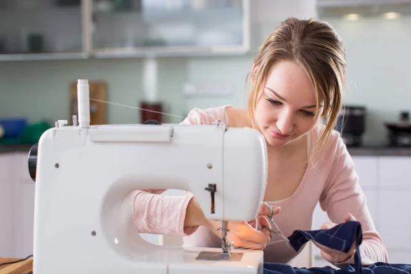 Hermosa mujer joven cosiendo ropa con máquina de coser —  Fotos de Stock