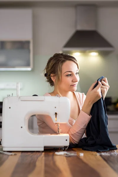 Vacker ung kvinna sy kläder med symaskin — Stockfoto