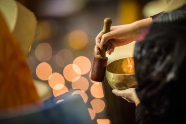 Adam bir tibetian şarkı kase üzerinde oynama