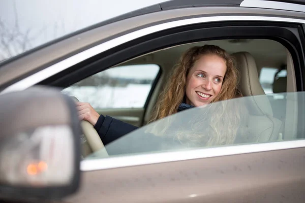 Досить молода жінка керує своєю новою машиною — стокове фото