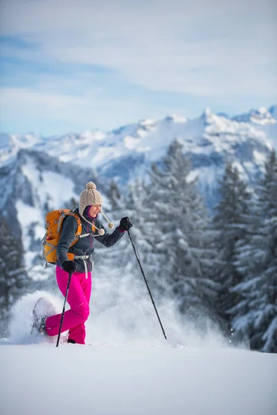Bonita, jovem mulher snowshoeing em altas montanhas — Fotografia de Stock