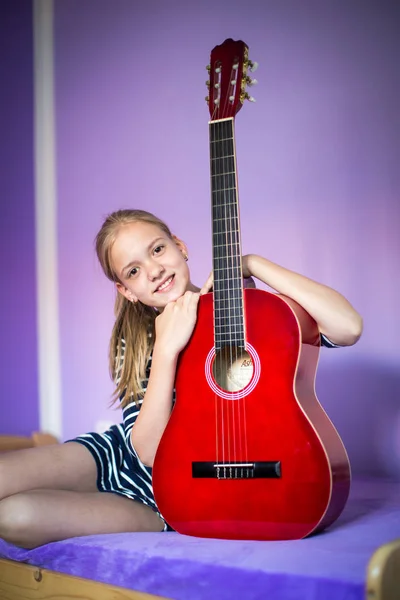 Ragazza adolescente con la sua chitarra nella sua bella stanza — Foto Stock