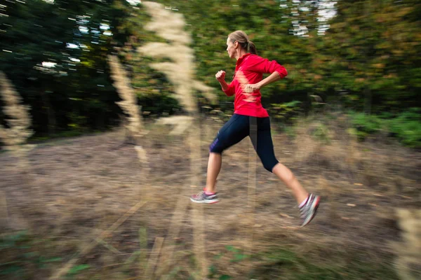 Junge Frau rennt im Wald ins Freie und ist schnell unterwegs — Stockfoto