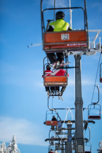 Ski lift with skiers being carried up the hill — Stock Photo, Image