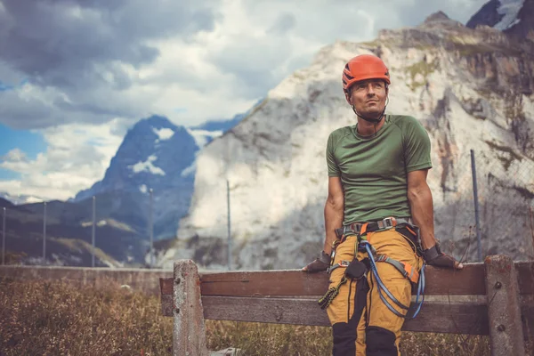 Młody człowiek wspina się na skałę w Alpach Szwajcarskich — Zdjęcie stockowe