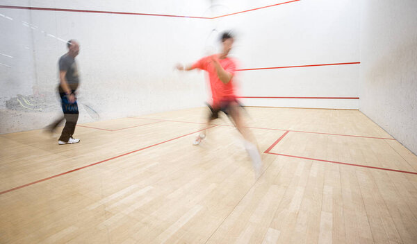 Squash players in action on a squash court 