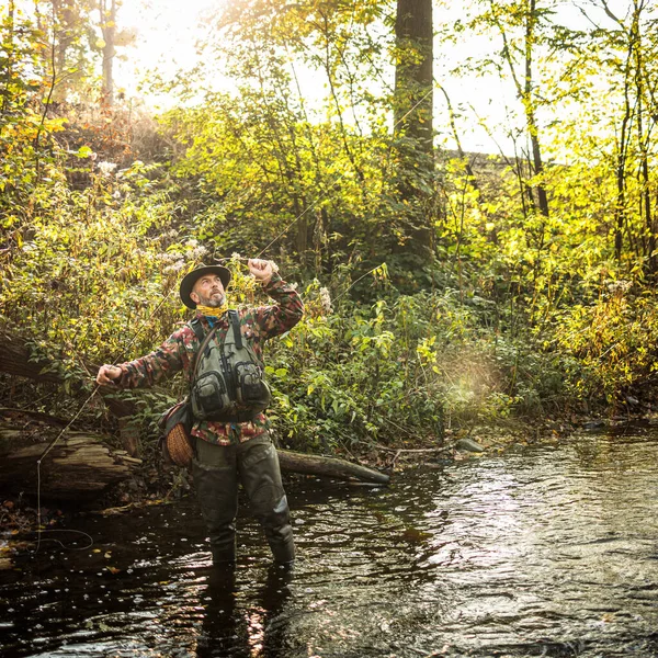 Pêcheur à la mouche travaillant la ligne et la canne à pêche pendant la pêche à la mouche — Photo