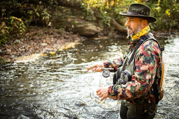 Flly fisherman holding a lovely trout while  fly fishing on a splendid mountain river — ストック写真