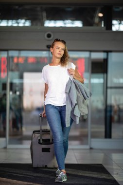 Uluslararası bir havaalanında bagajları ile genç kadın