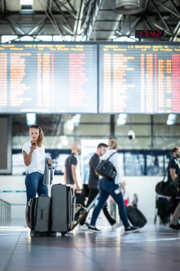 Uluslararası bir havaalanında bagajları ile genç kadın