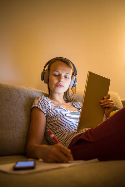 Mooie, jonge vrouw die 's avonds thuis werkt — Stockfoto