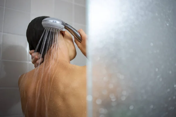 Bella, giovane donna che fa una lunga doccia calda lavandosi i capelli — Foto Stock