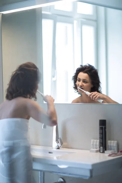 Mooie, middelbare leeftijd vrouw borstelen haar tanden — Stockfoto