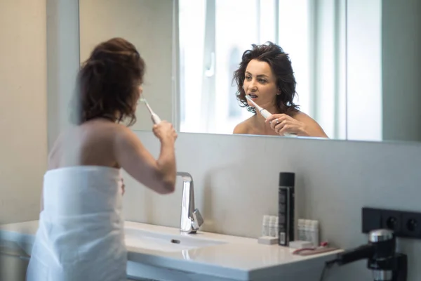 Mulher bonita e de meia-idade a escovar os dentes — Fotografia de Stock