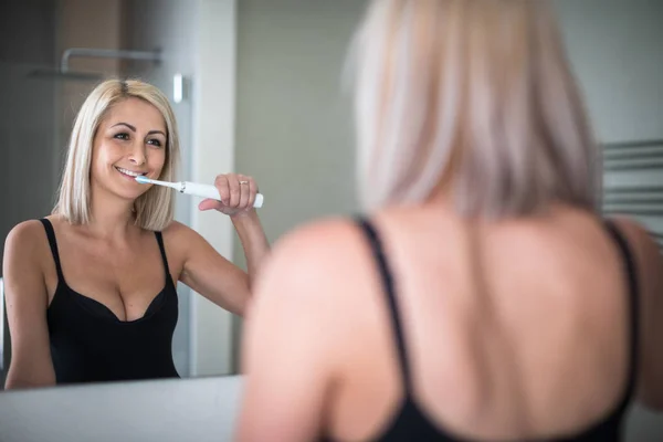 Красивая женщина средних лет чистит зубы — стоковое фото