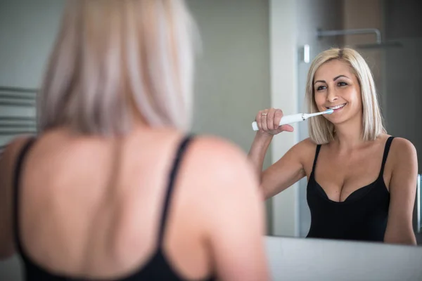 Όμορφη, μεσήλικη γυναίκα που βουρτσίζει τα δόντια της — Φωτογραφία Αρχείου