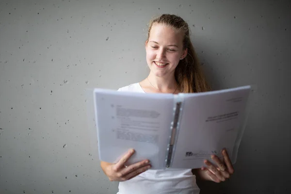 Bonito estudante universitário / colegial feminino com livros na biblioteca — Fotografia de Stock