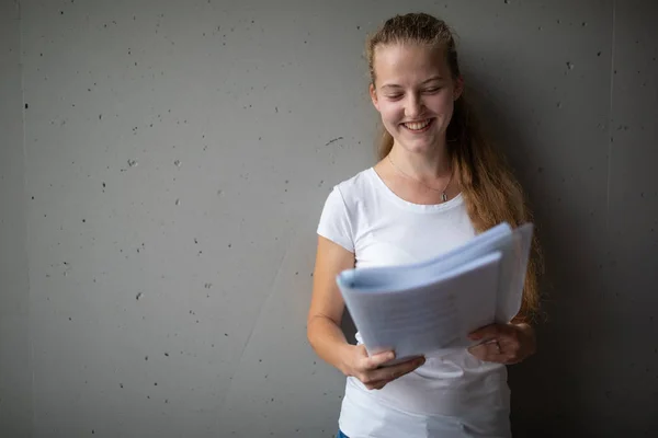 Bonito estudante universitário / colegial feminino com livros na biblioteca — Fotografia de Stock