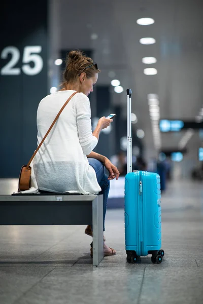 Uluslararası bir havaalanında bagajları ile genç kadın — Stok fotoğraf
