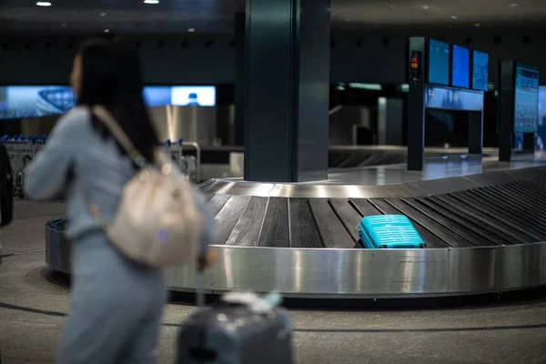 Personas en un aeropuerto internacional, en la zona de recogida de equipajes —  Fotos de Stock