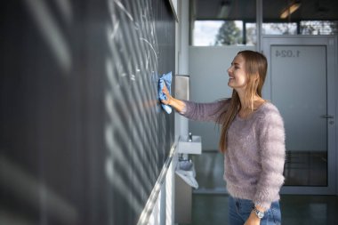 Bir tahta önünde güzel, genç kız öğrenci 