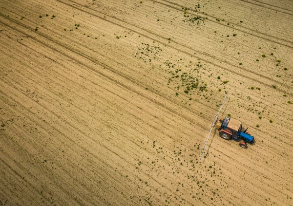 Traktor permetező növények a területen, légi kilátás drón pov — Stock Fotó
