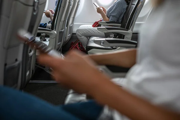 Passengers in abord a commercial flight using their cell phones — Stock Photo, Image
