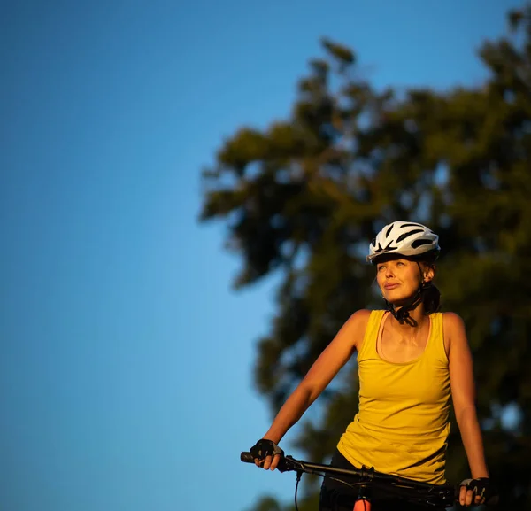 Mujer bonita y joven en bicicleta en una bicicleta de montaña — Foto de Stock