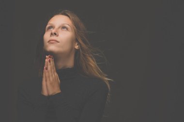 Genç bir kadın Tanrı 'ya dua ediyor.