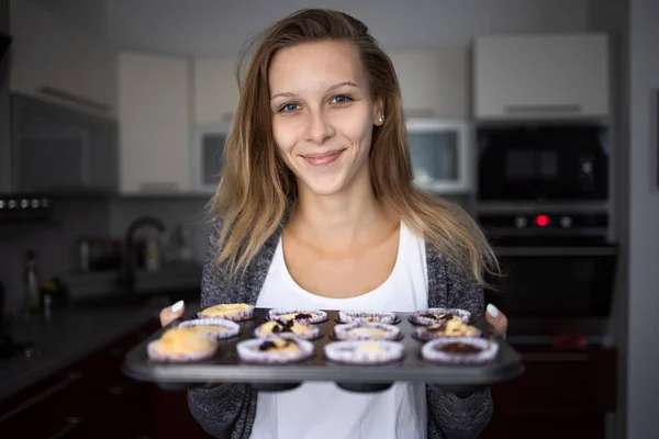 Pretty, young woman baking gluten free cupkes — 스톡 사진