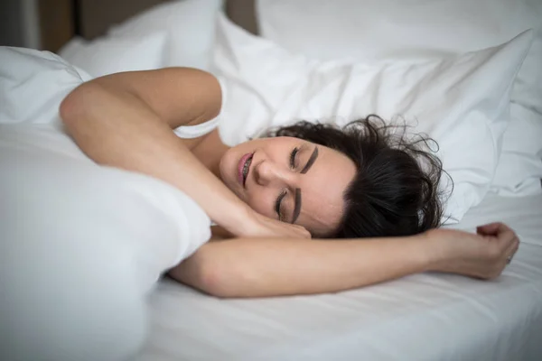 Красива молода жінка спить на ліжку — стокове фото